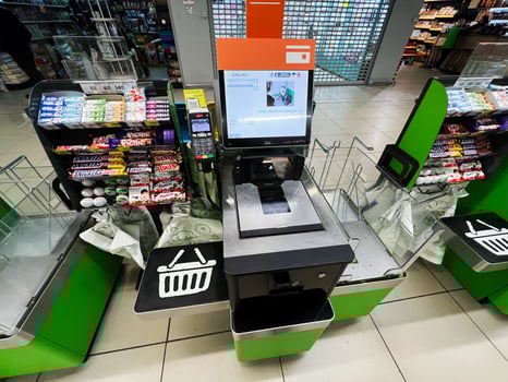 Kyiv, Ukraine - February 04, 2025 Modern supermarket self checkout terminal with snacks and bags surrounding the area photo