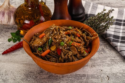A bowl of noodles with vegetables and garlic photo