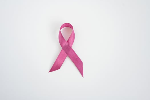 Pink ribbon on white background symbolizing breast cancer awareness and support. Childhood Cancer Awareness Month photo