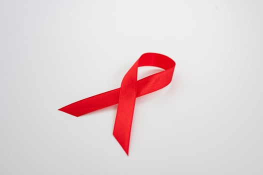 Red awareness ribbon symbol against white background. National Youth HIV and AIDS Awareness Day photo