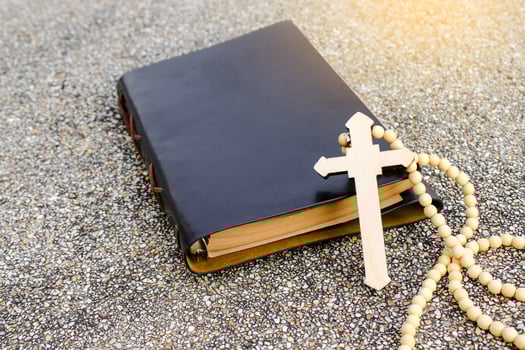 White ivory cross placed on a brown notebook reflects purity, peace, and divine guidance. The contrast symbolizes light amidst darkness, faith, and personal devotion. photo