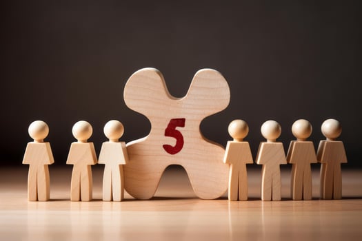 Wooden figures standing near number five leadership and teamwork concept photo