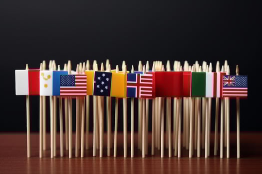 Small flags of different countries standing on toothpicks on black background photo