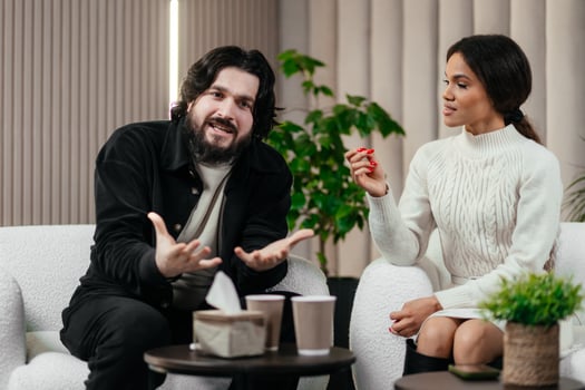 Multiethnic young couple on consultation with therapist. Black young woman discusses relationship problems. Unhappy caucasian man listens his girlfriend. Couples therapy photo
