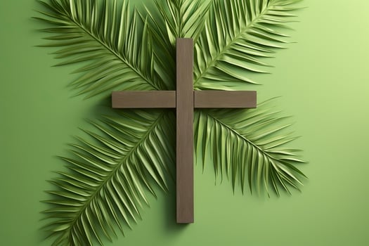 Christian cross surrounded by palm leaves symbolizing palm sunday on green background photo