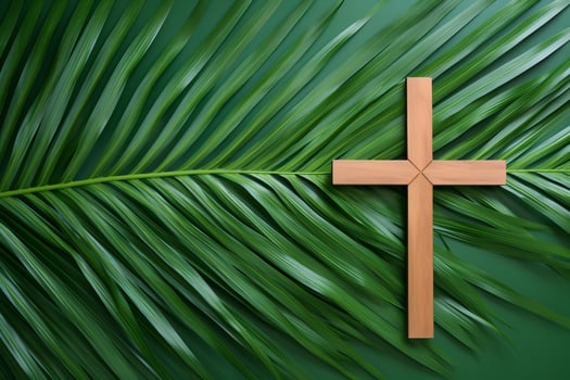 Wooden christian cross resting on palm leaves symbolizing palm sunday photo