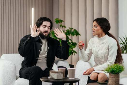 Nervous American man loses temper. Multiethnic couple having conflict during couples therapy with psychologist. African black woman argue with her husband. Psychological therapy, personal crisis photo