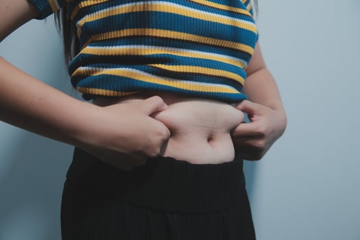 A woman with a belly showing off her stomach photo