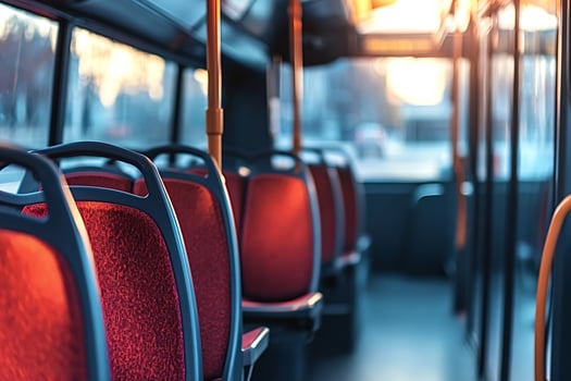 Empty city bus interior showing red seats at sunset photo