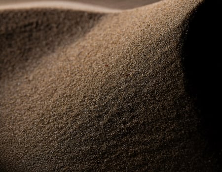 Front View of Brown Sand Spread on Black Surface photo