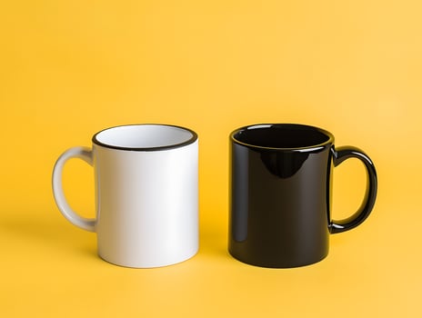 Two black and white mugs on a yellow background photo
