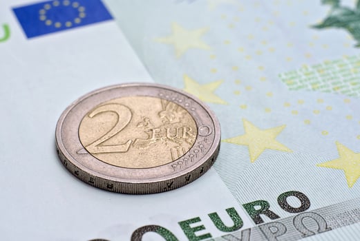 Coin two euros on the banknote of hundred euro photo