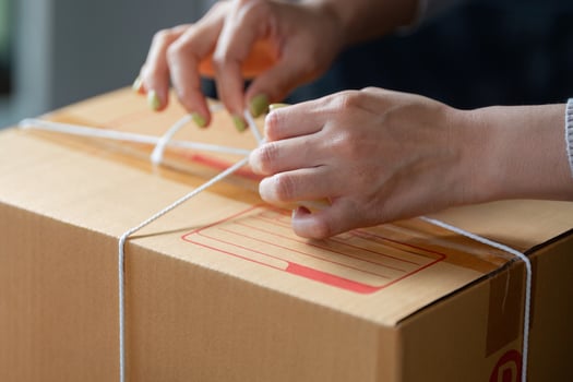 Muslim woman tying package for online order fulfillment at her home office. photo
