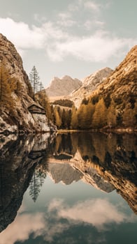 Scenic mountain landscape reflecting in tranquil lake under a blue sky with clouds. photo