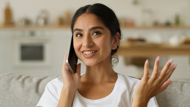 Happy smiling Indian woman Arabian lady Muslim girl Islamic female smile friendly talking mobile phone at home talk smartphone call friend order food delivery communicate conversation speak device photo
