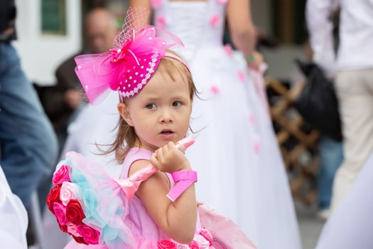 A little girl with a bouquet of the bride in a pink dress with a big bow.A child at a wedding. photo