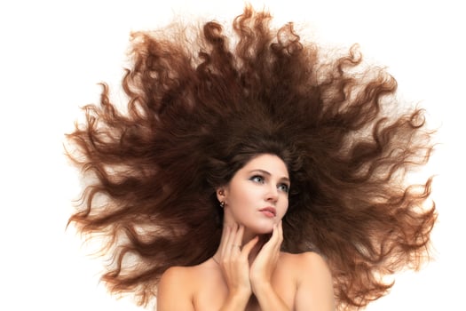 A brunette woman scattered her long luxurious hair on a white background. photo