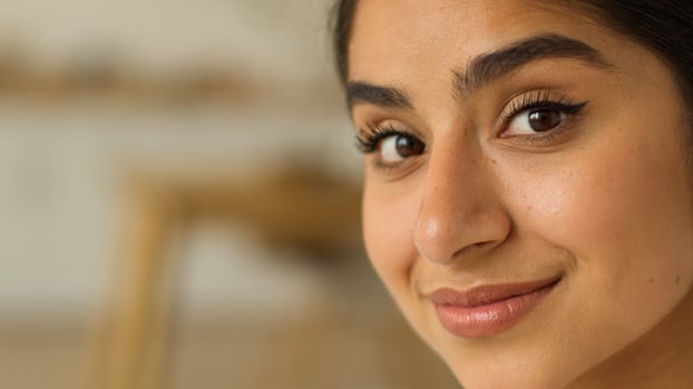 Close up face portrait smiling cheerful satisfied charming attractive beautiful happy healthy Indian woman Arabian girl lady female at home indoors looking at camera make up cosmetology dermatology photo