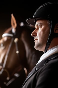 A skilled equestrian rider stands confidently next to a polished horse, dressed in tailored luxury attire photo