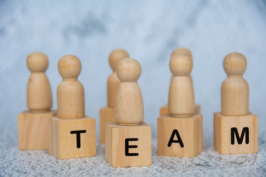 TEAM text on wooden cubes with wooden figures on top. Teamwork concept photo