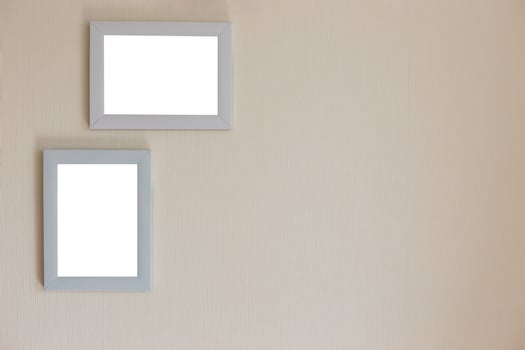 Two white frames on a beige wall photo