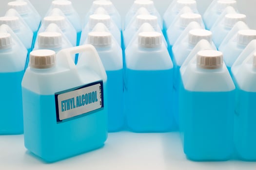 Containers of ethyl alcohol arranged in a neat formation showcasing a bright blue liquid photo
