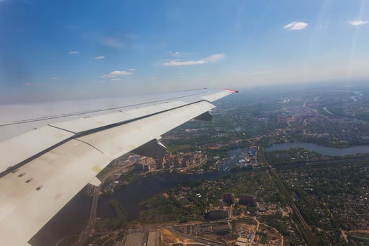 Aerial view of cloud blue sky and plane wing view through the airplane window. photo