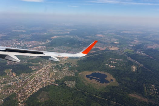 Aerial view of cloud blue sky and plane wing view through the airplane window. photo