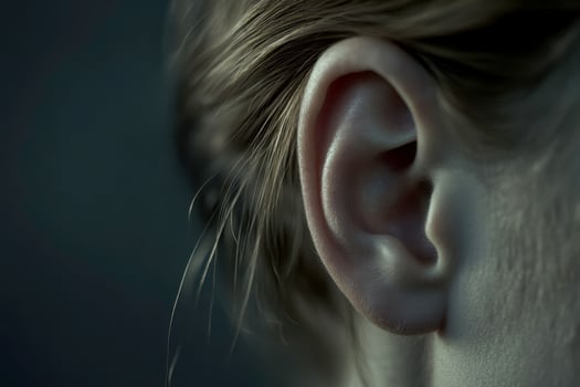 Cropped detail close up photo of the head. female human ear without accessory and hair. Skincare cosmetic treatment..