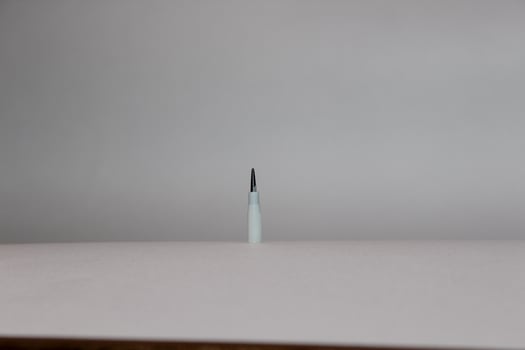 A single white toothbrush on a white surface photo