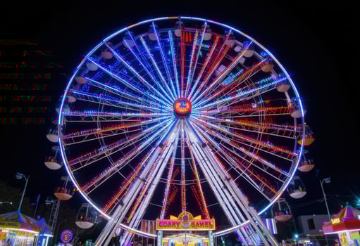 A ferris wheel at night with colorful lights photo