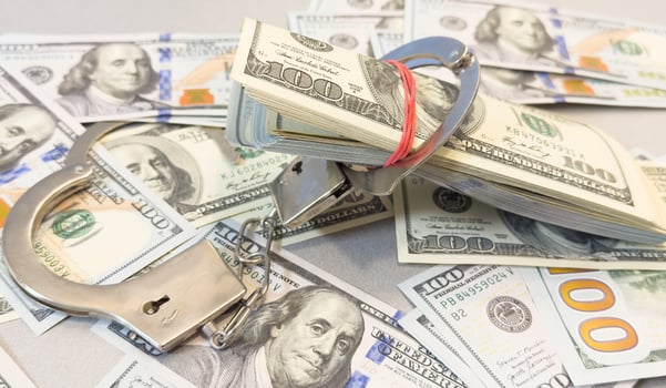 Pair of metal police handcuffs on Euros banknotes money cash background. Corruption, dirty money, gambling or financial crime ideas concept. photo