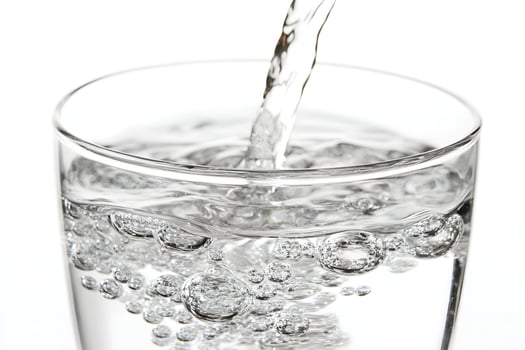 Clear water pouring into a glass. photo