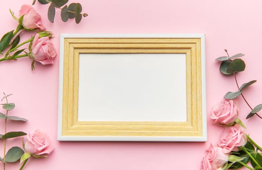Wooden frame decorated with pink roses on pink background for valentine's day photo