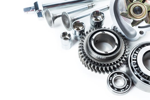 Various metallic components and tools arranged on a white surface for automotive or mechanical use photo