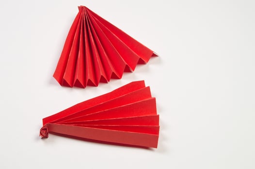 Two red origami fans on white surface photo