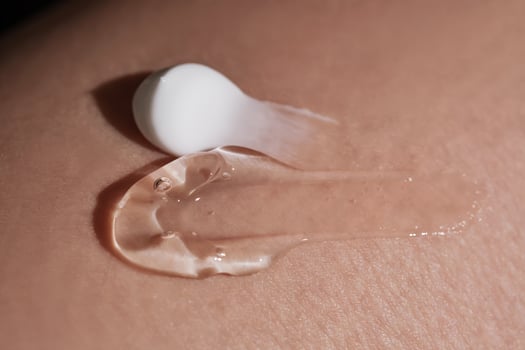 White body cream and a moisturizing gel on dry human skin. photo