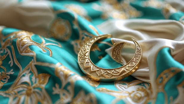 Elegant golden crescent placed on rich turquoise fabric with intricate embroidery during a cultural celebration photo