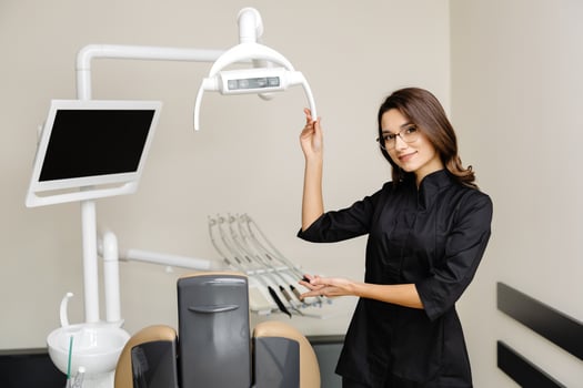 Young female dentist in modern clinic. A female dentist kindly invites you to an appointment. photo
