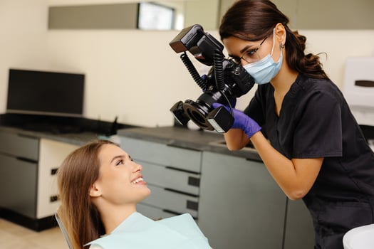 Dentist woman photographing with professional camera the result of work photo