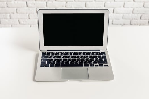 Laptop on a clean white desk with a minimalistic background in a bright room photo