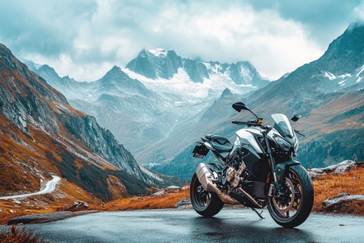 Motorcycle parked on a mountain road overlooking the Alps photo