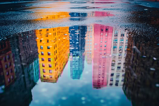 Colorful buildings reflecting in a puddle on a rainy day photo