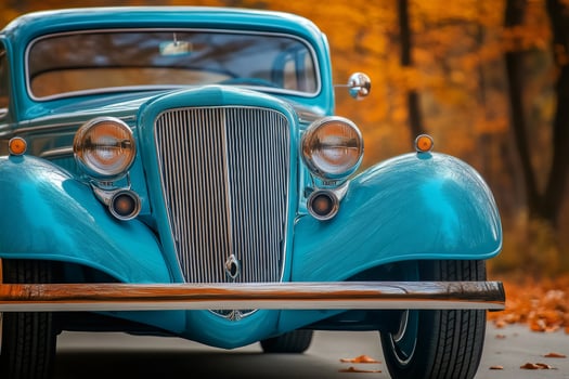 Restored light blue vintage car parked on an autumn road photo