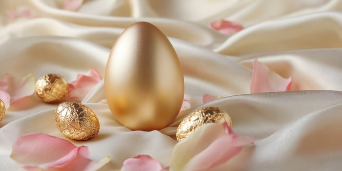 Luxurious Easter composition with golden eggs and pink petals on satin fabric photo