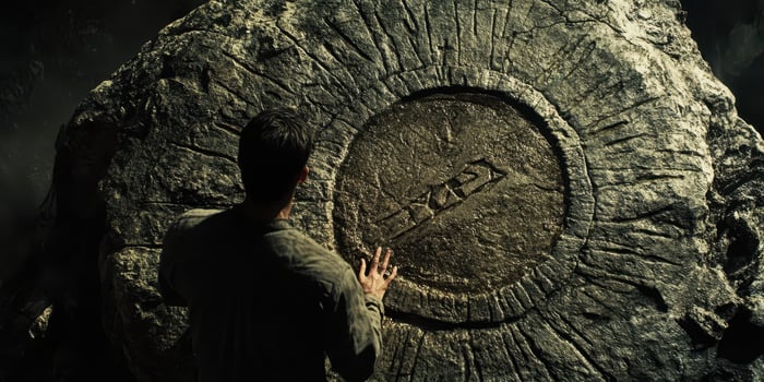 Man touching a stone circle carving with ancient symbols photo