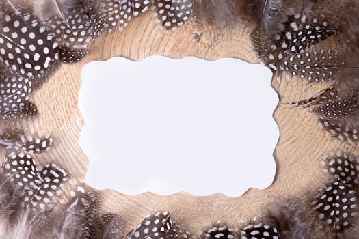 Flat lay blank greeting card mock up easter on a wooden background and feathers around. photo