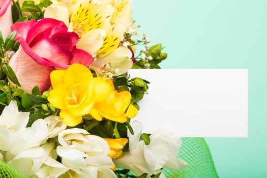 Brightly colored flower bouquet with assorted blooms against a pastel background before an event or celebration photo