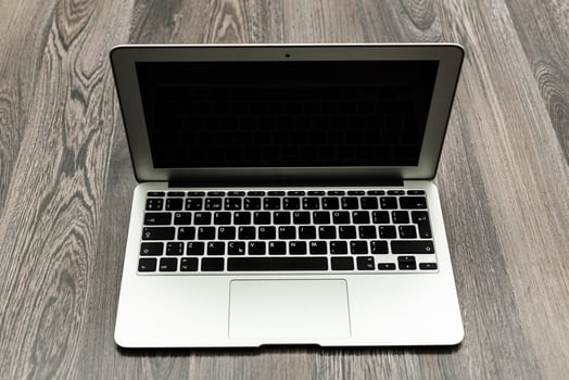 Laptop placed on wooden surface, ready for use or showcasing its sleek design in a modern workspace setting photo