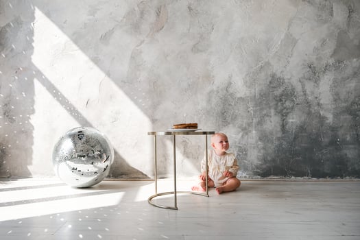 A baby sitting on a table in front of a wall photo